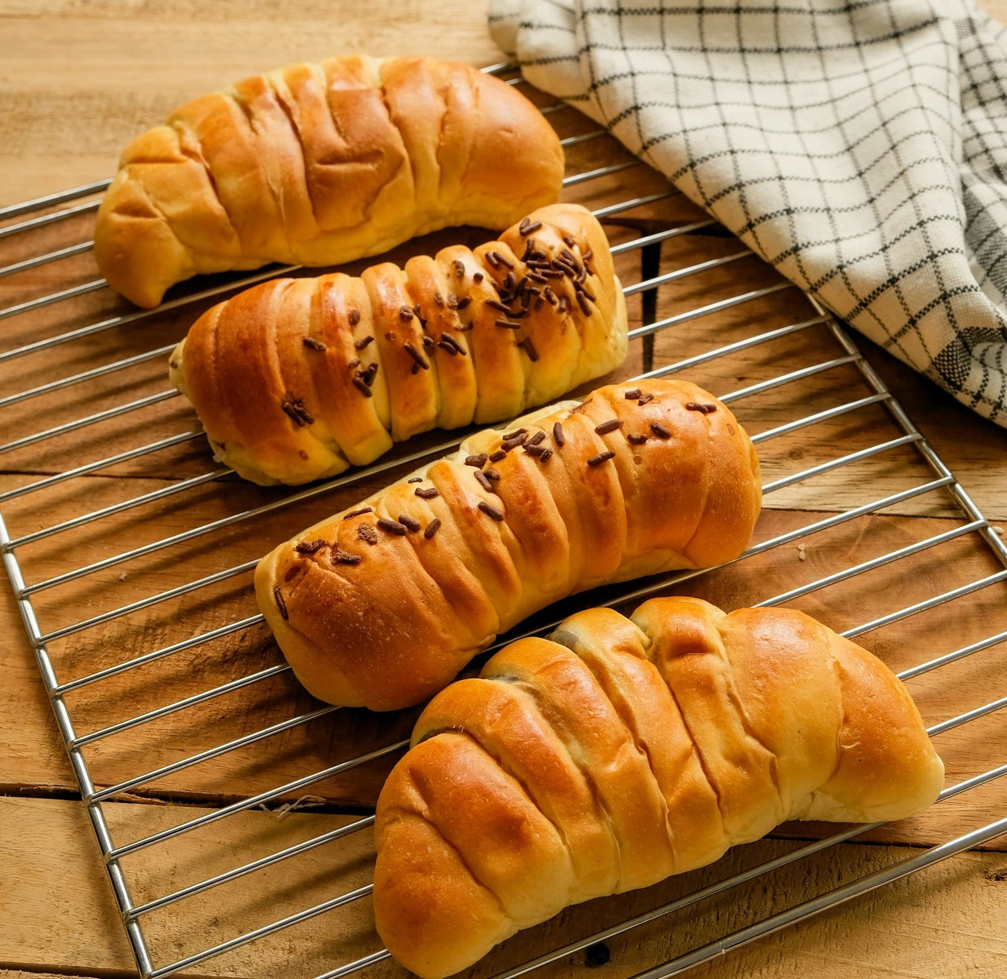 three long loafs of bread sitting on a cooling rack